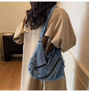 Sac cabas en denim délavé bleu avec plusieurs fermetures éclair et large bandoulière