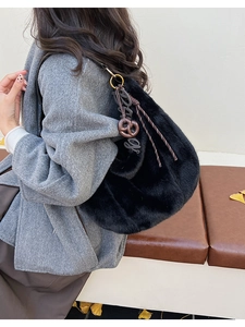 Détail du sac bandoulière en fausse fourrure noire avec anneau et breloque sur mannequin
