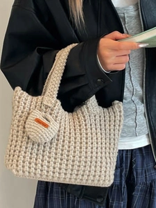 Minimalist beige crochet handbag with chunky knit texture and handmade charm detail