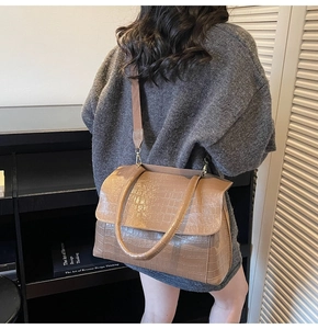 Fashionable khaki crocodile pattern tote bag with adjustable brown wide strap on model
