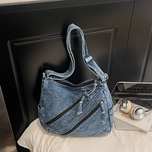 Détail du sac fourre-tout en denim bleu avec poches zippées et bandoulière large réglable
