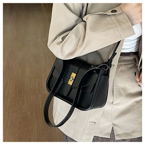 Dettaglio borsa a tracolla in pelle nera con elegante chiusura a girello rettangolare oro