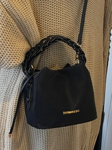 Classic black drawstring bucket bag with woven ring handle and elegant gold metal logo