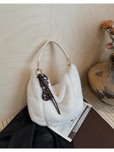 Détail du sac hobo en fausse fourrure blanche avec poignée cuir et breloque marron