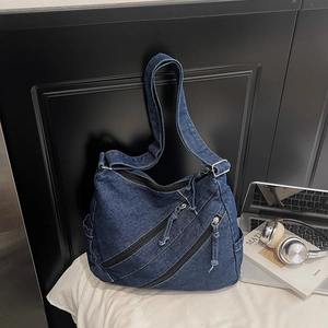 Vue détaillée du sac en jean avec fermetures éclair et bandoulière réglable