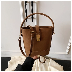 Detailansicht der braunen Bucket Bag aus mattem Leder mit bronzenem Metallschloss