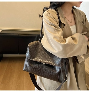 Brown crocodile texture shoulder bag styled with two straps and classic trench coat