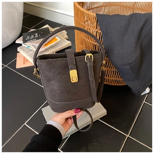 Detailaufnahme der dunkelgrauen Beuteltasche mit goldener Schnalle und matter Textur