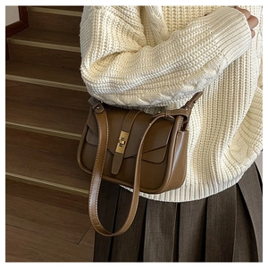 Borsa a tracolla marrone opaco in pelle con fibbia in metallo vintage indossata dal modello