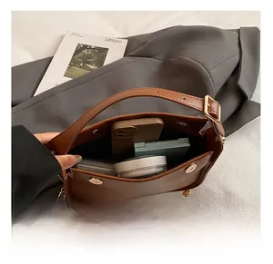 Détails de l'intérieur du sac marron avec bandoulière chaîne dorée et fermoir magnétique