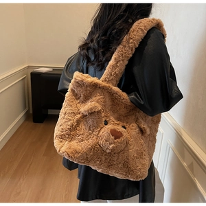 Détail d'un sac cabas en peluche marron avec broderie d'ours et texture en fausse fourrure