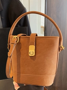 Retro Eimertasche in Karamellbraun mit mattem Lederfinish und goldener Metallschnalle