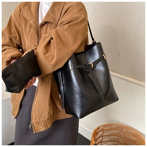 Close-up of minimalist black leather tote bag with small matching zipper pouch for women