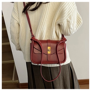 Borsa a tracolla rosso vino con fibbia dorata abbinata a maglione bianco e gonna marrone