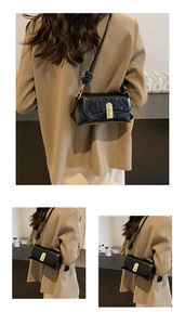 Détail d'un sac à bandoulière noir brillant avec texture plissée et fermoir doré chic