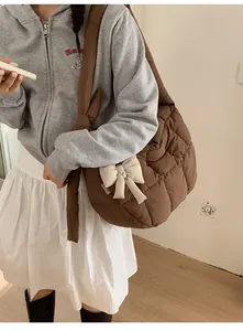 Vue détaillée du sac matelassé marron avec un nœud décoratif blanc crème élégant
