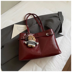 Détail du grand sac cabas bordeaux en cuir plissé brillant avec boucles et porte-clé ours
