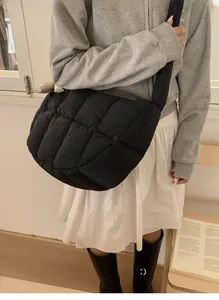 Détail du sac bandoulière matelassé noir avec une large bandoulière de style nuage