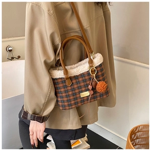Dettaglio della borsa a secchiello vintage a quadri con tracolla e bordo in peluche