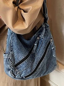 Sac hobo chic en jean bleu délavé avec poches zippées présenté sur un mannequin