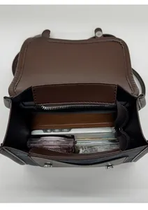 Vertical top view showing the capacity of the compact brown flap bag with daily essentials