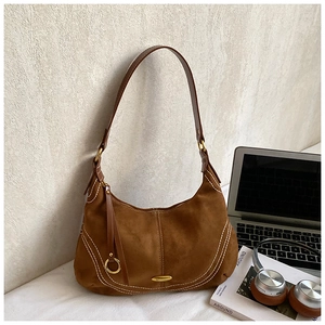 Detail of brown suede hobo bag with contrast stitching and metal ring charm