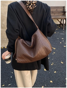 Vue détaillée du sac hobo en cuir PU tressé marron porté avec une bandoulière large