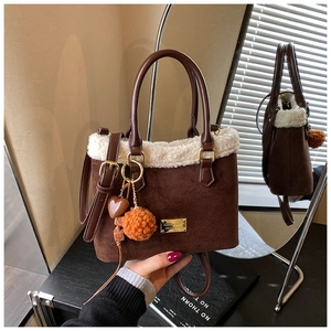 Details der Plüsch-Eimertasche mit Lammfellbesatz und dekorativem Herzanhänger