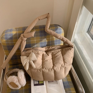 Détail du sac bandoulière beige matelassé avec nœud décoratif et bandoulière nouée