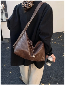 Gros plan détaillé du sac hobo en cuir tressé marron foncé avec bandoulière et style urbain chic