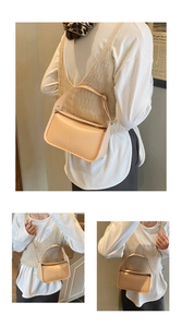 Détail d'un sac bandoulière crème avec chaîne en métal doré et large poignée en cuir