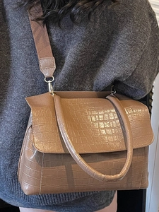 Brown crocodile embossed tote bag with round handles and wide fabric shoulder strap