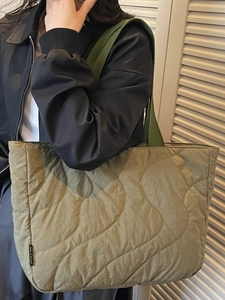 Minimalist dark green quilted tote bag with wave stitching and wide shoulder straps