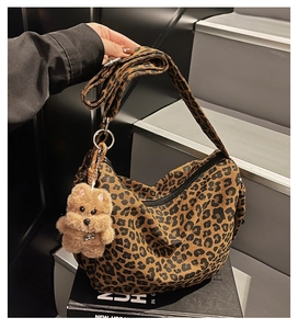 Detail of hobo bag with leopard print canvas texture and cute plush bear charm decoration