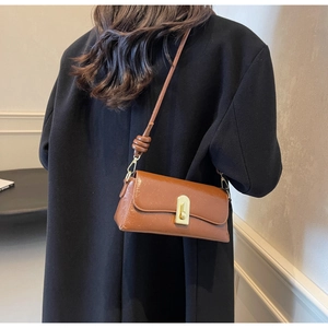 Détail d'un sac à bandoulière marron vintage avec texture huilée et fermoir doré