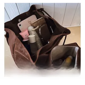 Top view of a brown leather tote bag interior showing large capacity and an inner zipper pouch