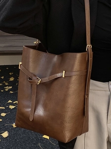 Minimalist vintage brown bucket shoulder bag in matte leather with gold hardware detail