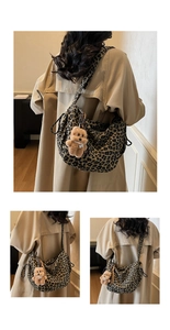 Detail of leopard print hobo bag with plush bear charm and spacious fabric design
