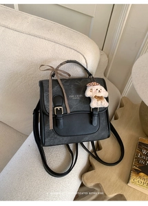 Detail view of a retro grey backpack with PU leather trim and a cute plush puppy charm