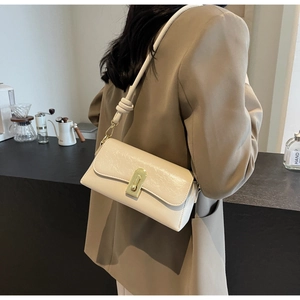 Détail du sac à bandoulière minimaliste beige en similicuir avec boucle dorée rotative