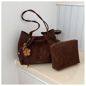 Detail view of brown tote bag set with matching pouch and decorative floral charm
