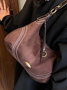 Brown frosted leather hobo bag with contrast stitching and shoulder strap on model