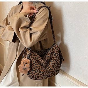 Retro leopard print shoulder bag with plush bear charm worn by model in natural light