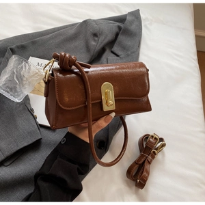 Vue détaillée du sac à bandoulière marron avec texture vintage et boucle dorée élégante