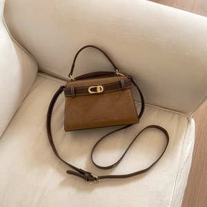 Close-up of vintage brown suede satchel with leather trim and gold hardware details