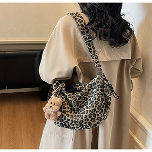 Detail of leopard print hobo bag with adjustable shoulder strap and cute bear charm