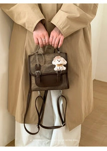 Brown retro flap backpack featuring a cute white puppy plush charm and bow decoration