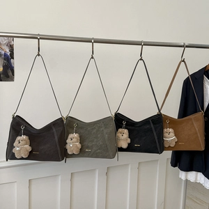 Détail de quatre sacs à bandoulière demi-lune colorés avec texture cuir et breloques en peluche