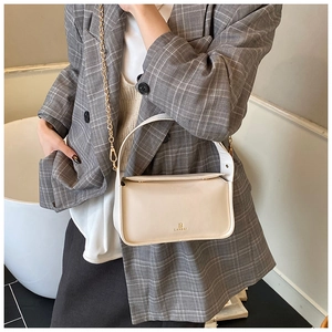 Détail du sac boîte beige minimaliste avec logo LANBAI doré et bandoulière en chaîne