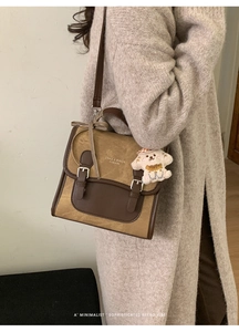Detail of vintage patchwork satchel with metal buckles and cute plush dog charm